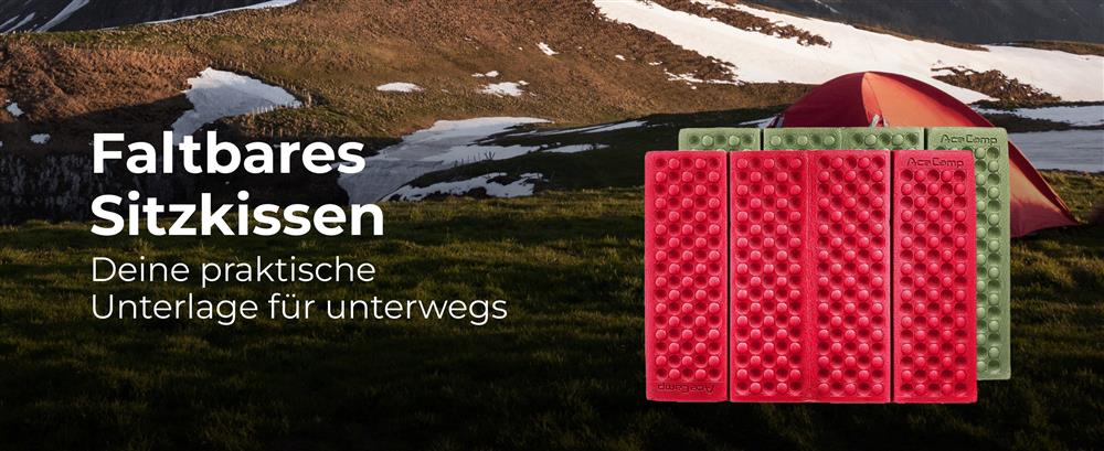 Person sitzt auf AceCamp Faltbarem Sitzkissen beim Wandern auf Felsen